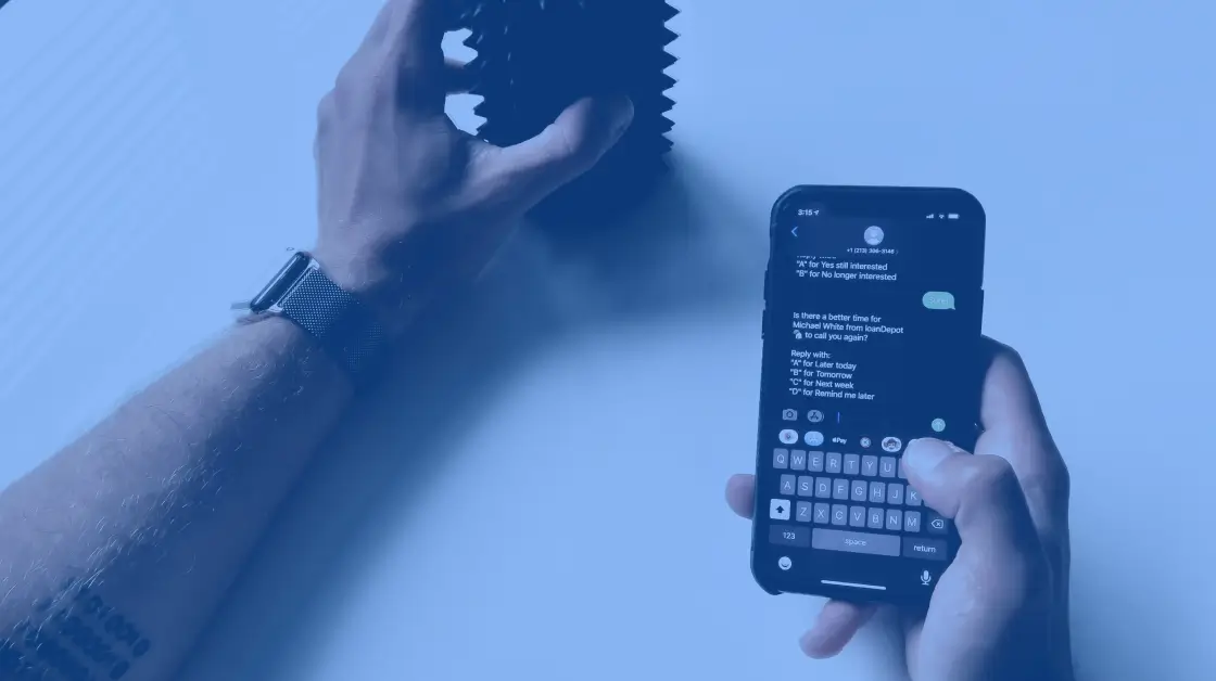 automated text message for business - picture of a white hand holding a mug, another hand is holding a phone